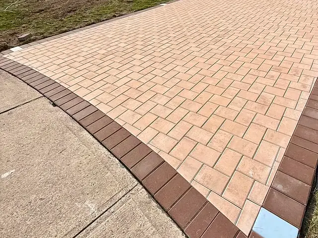 New paver driveway with a red soldier-course border