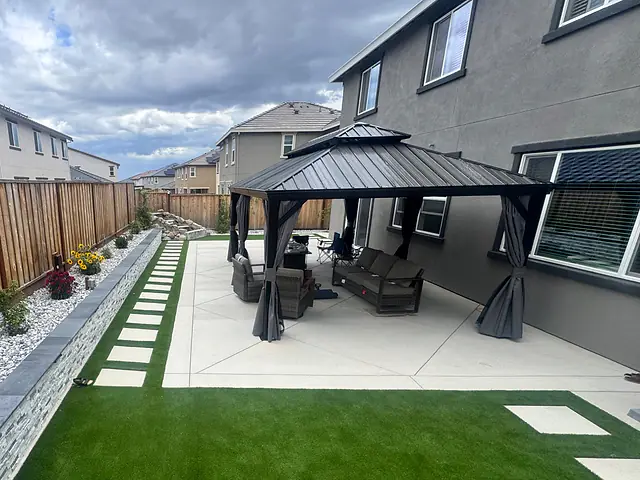 Hardtop gazebo over lounge seating on a new concrete patio, built by CM Hardscape