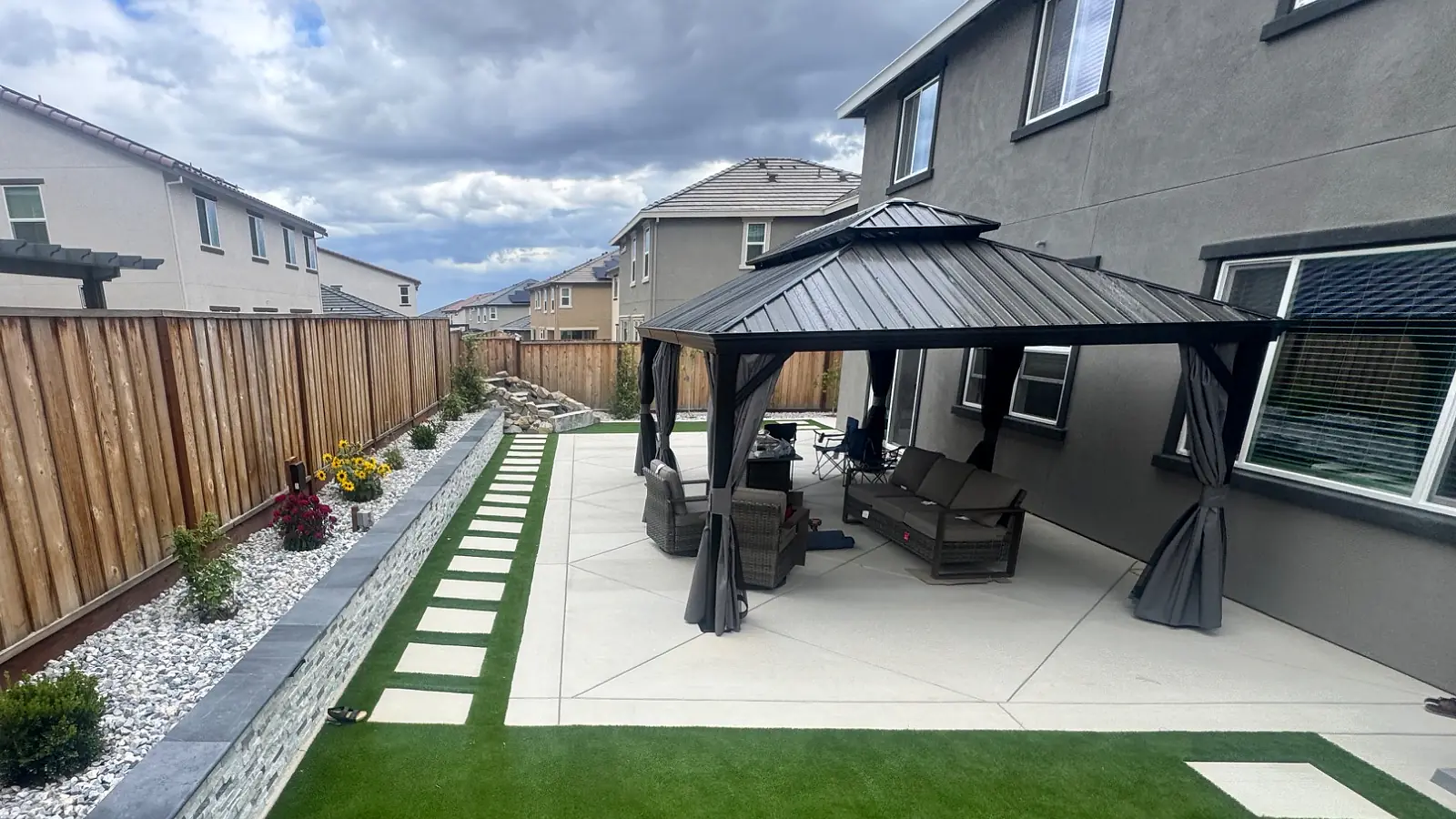 Hardtop gazebo over lounge seating on a new concrete patio, built by CM Hardscape