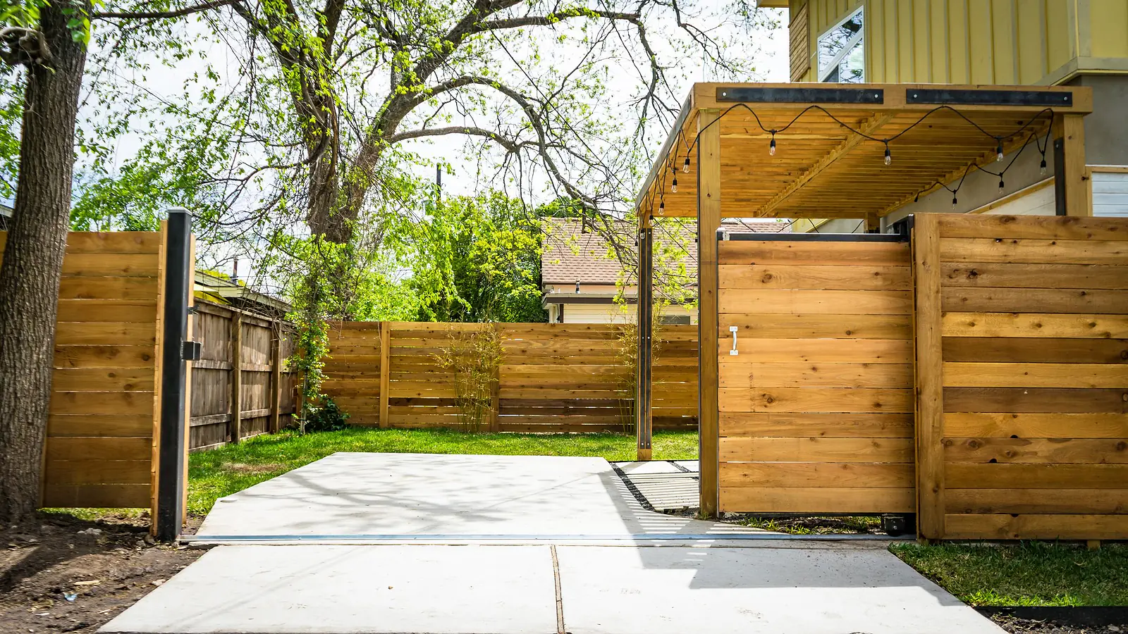 New horizontal cedar privacy fence and gate around a residential backyard