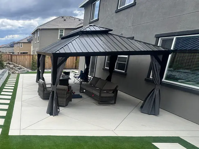Hardtop gazebo with curtains on a new concrete patio, installed by CM Hardscape