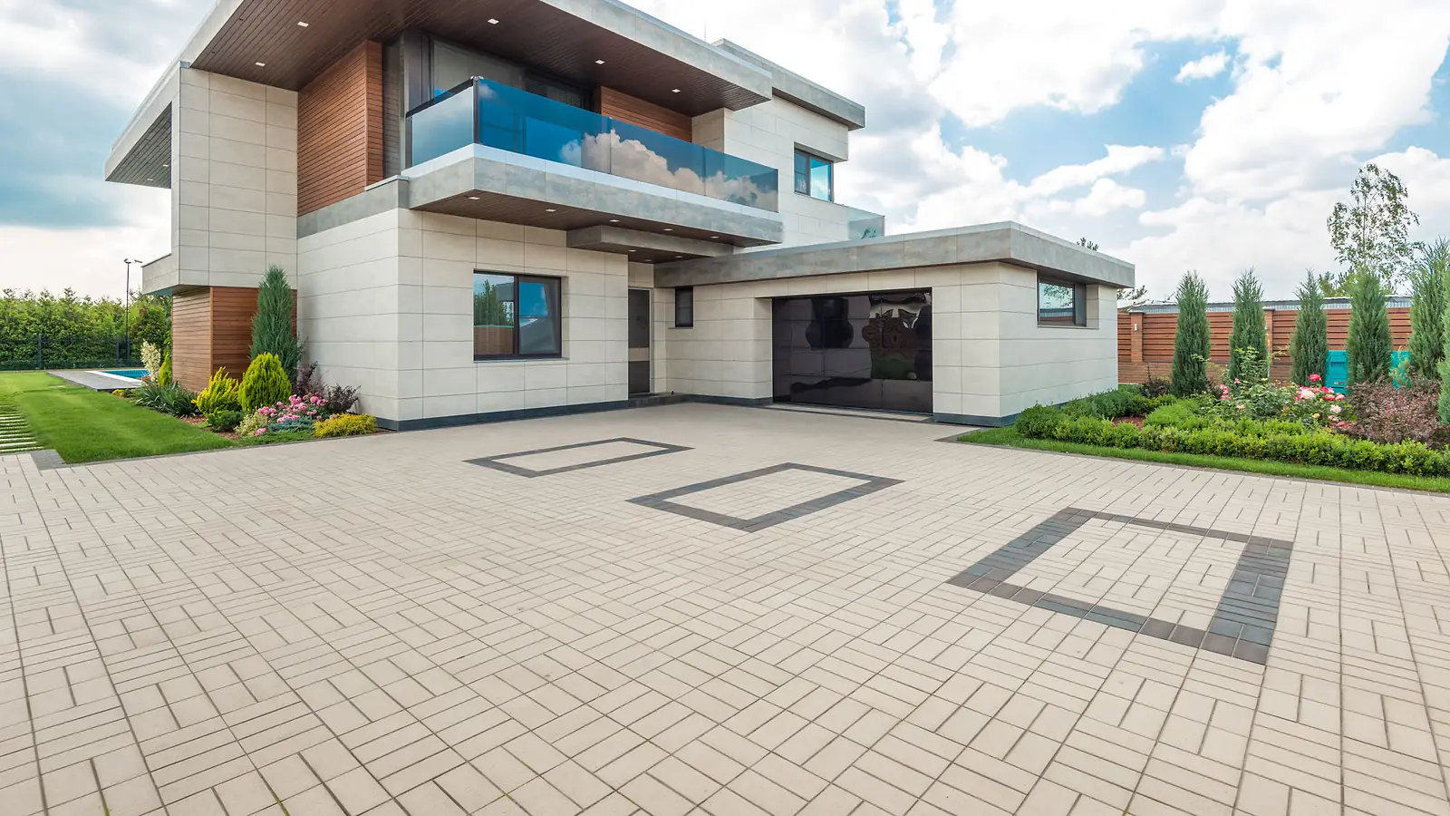 Large interlocking paver driveway in front of a modern home